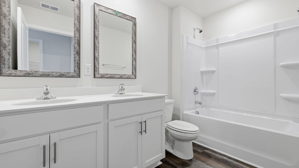 Bathroom with double vanity sink and bathtub.
