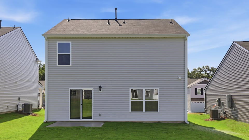 Back exterior of home with large backyard.