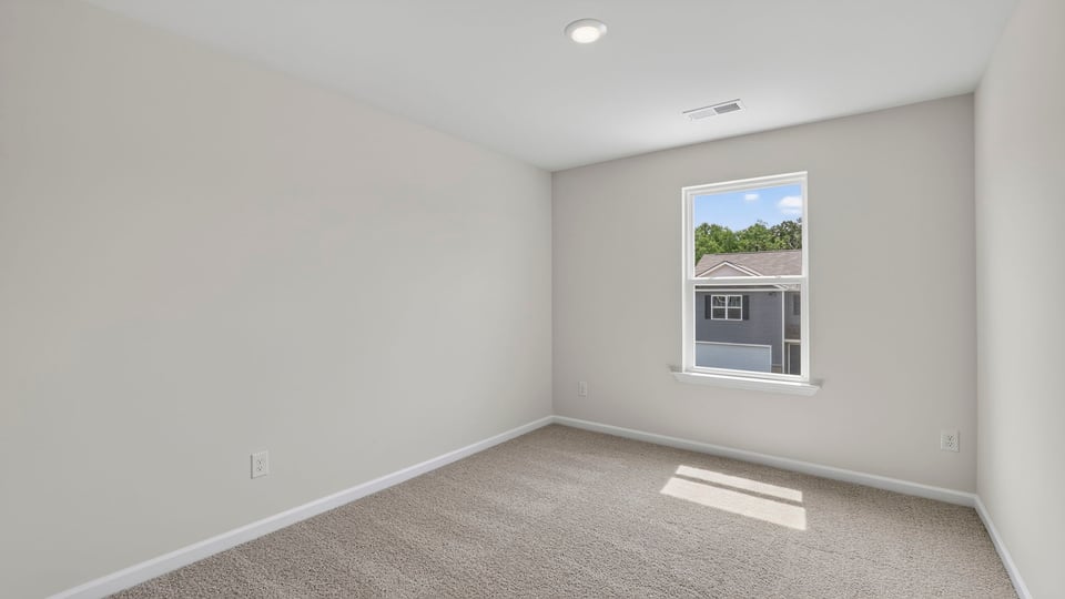 Bedroom with carpet and windows.