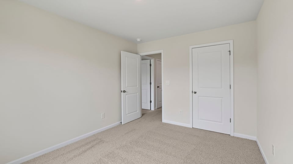 Bedroom with carpet and windows.