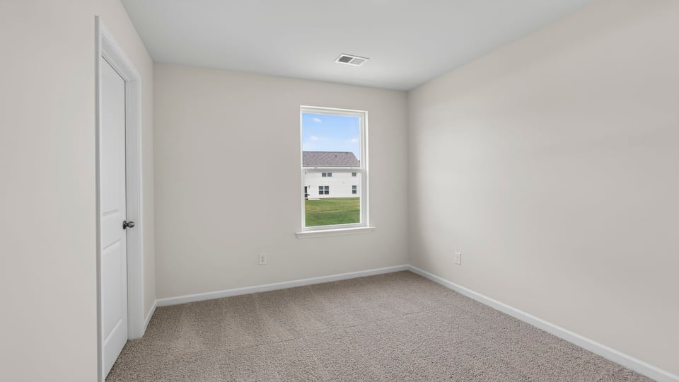 Bedroom with carpet and windows.