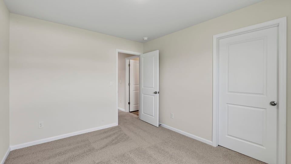 Bedroom with carpet and windows.