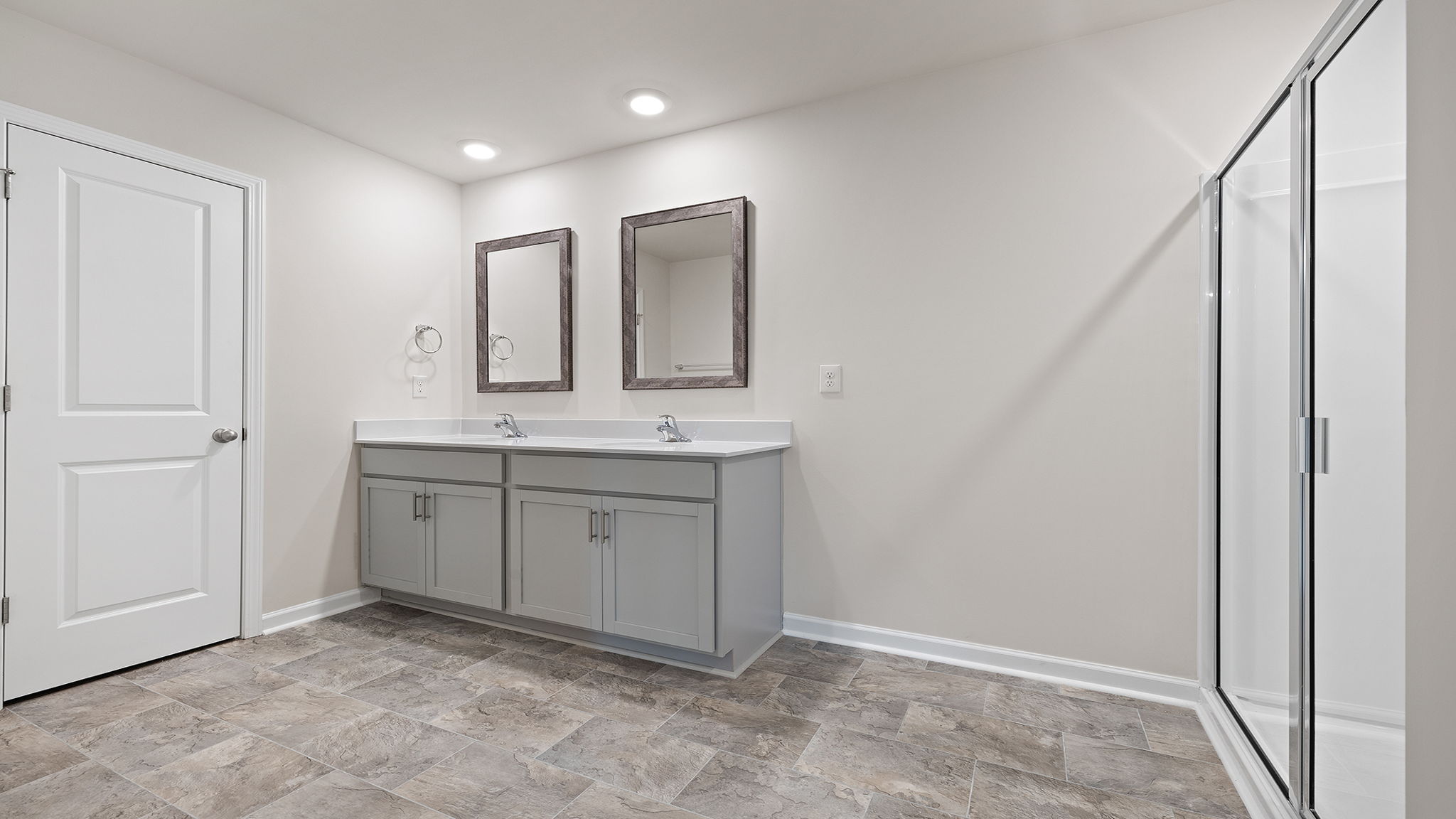Primary bathroom with dual sink vanity and mirrors.