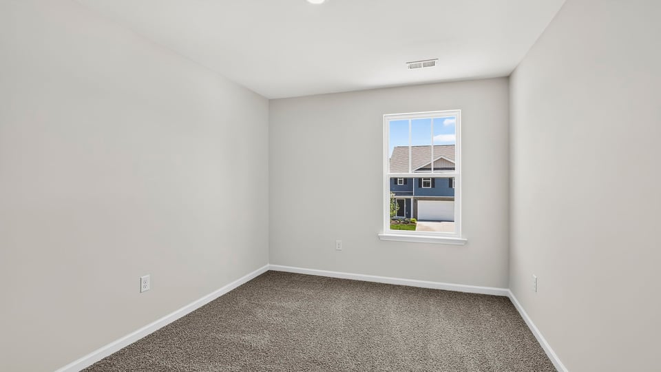 Bedroom with carpet and windows.