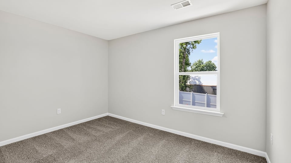 Bedroom with carpet and windows.