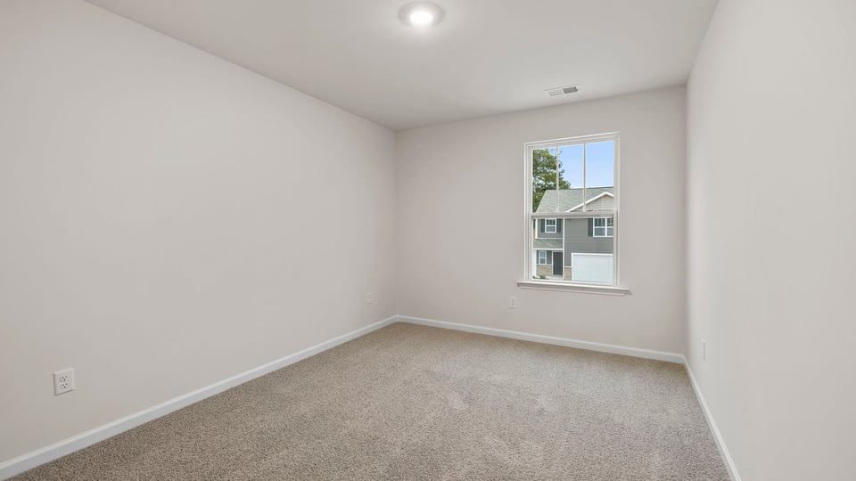 Bedroom with window and carpet.