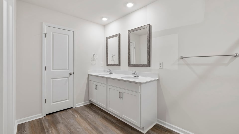 Primary bathroom with dual sink vanity and mirrors.