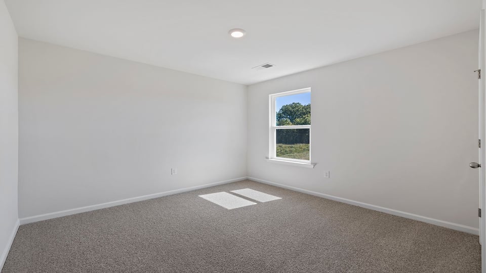 Bedroom with window and carpet.