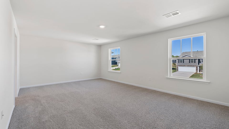 Primary bedroom with window and carpet.