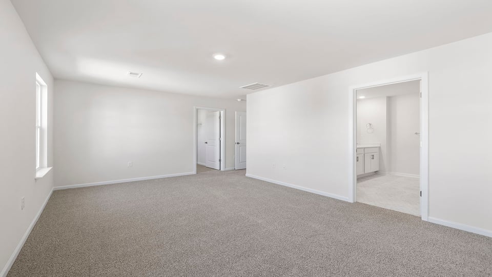 Primary bedroom with window and carpet.