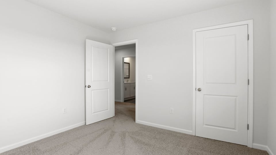 Bedroom with carpet and windows.