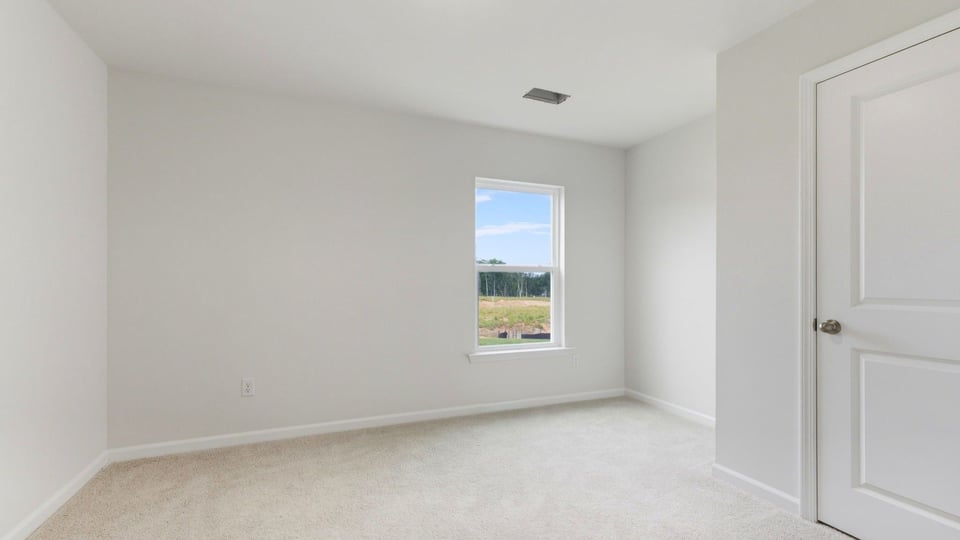Bedroom with carpet and window.