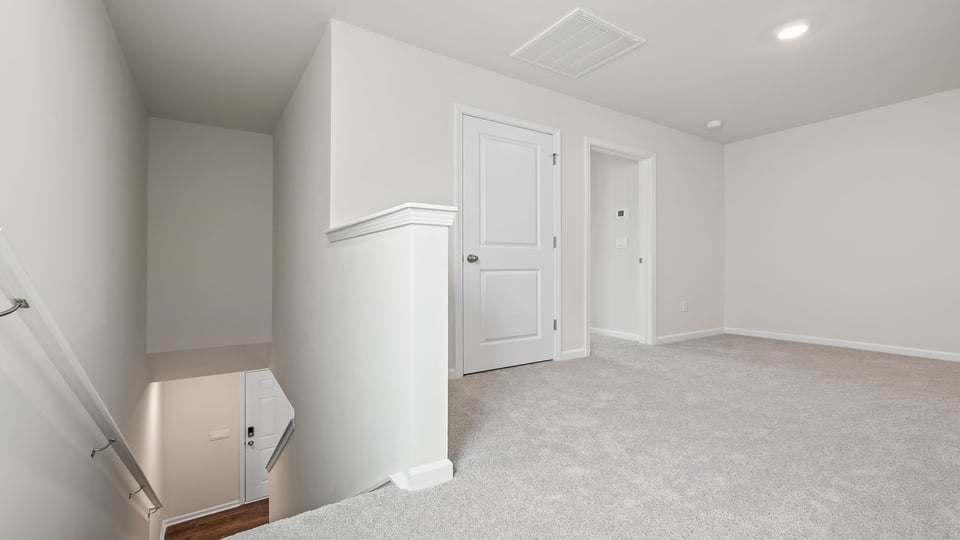 Loft area with carpet and window.