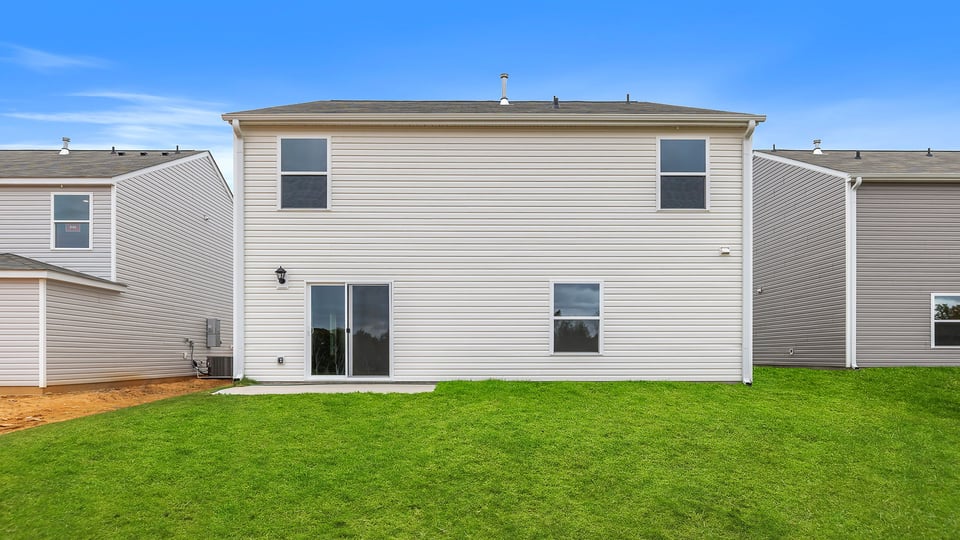 Back exterior with large backyard and patio.
