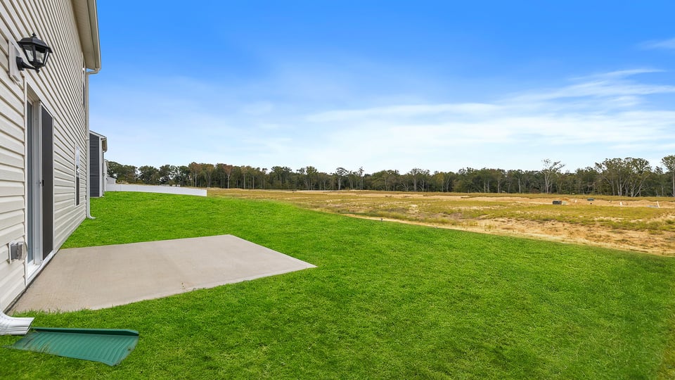 Back exterior with large backyard and patio.