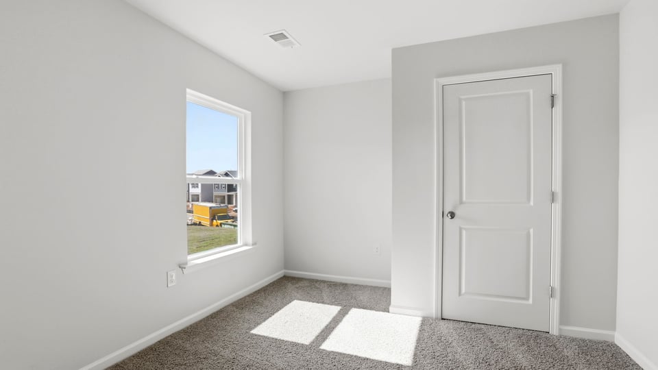 Bedroom with carpet and window.