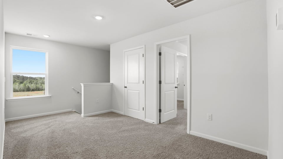 Loft area with carpet and window.