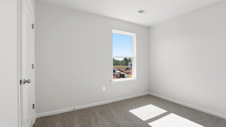 Bedroom with carpet and window.