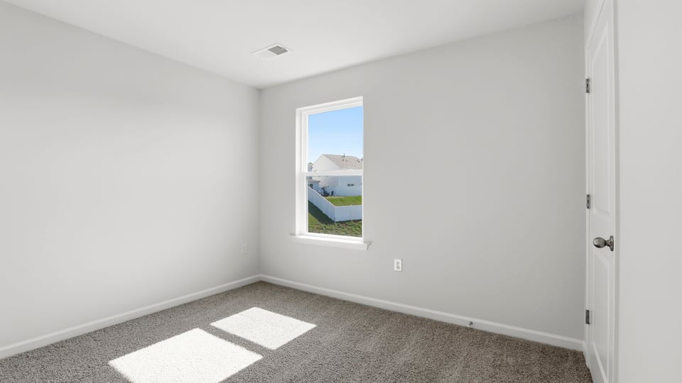 Bedroom with carpet and window.
