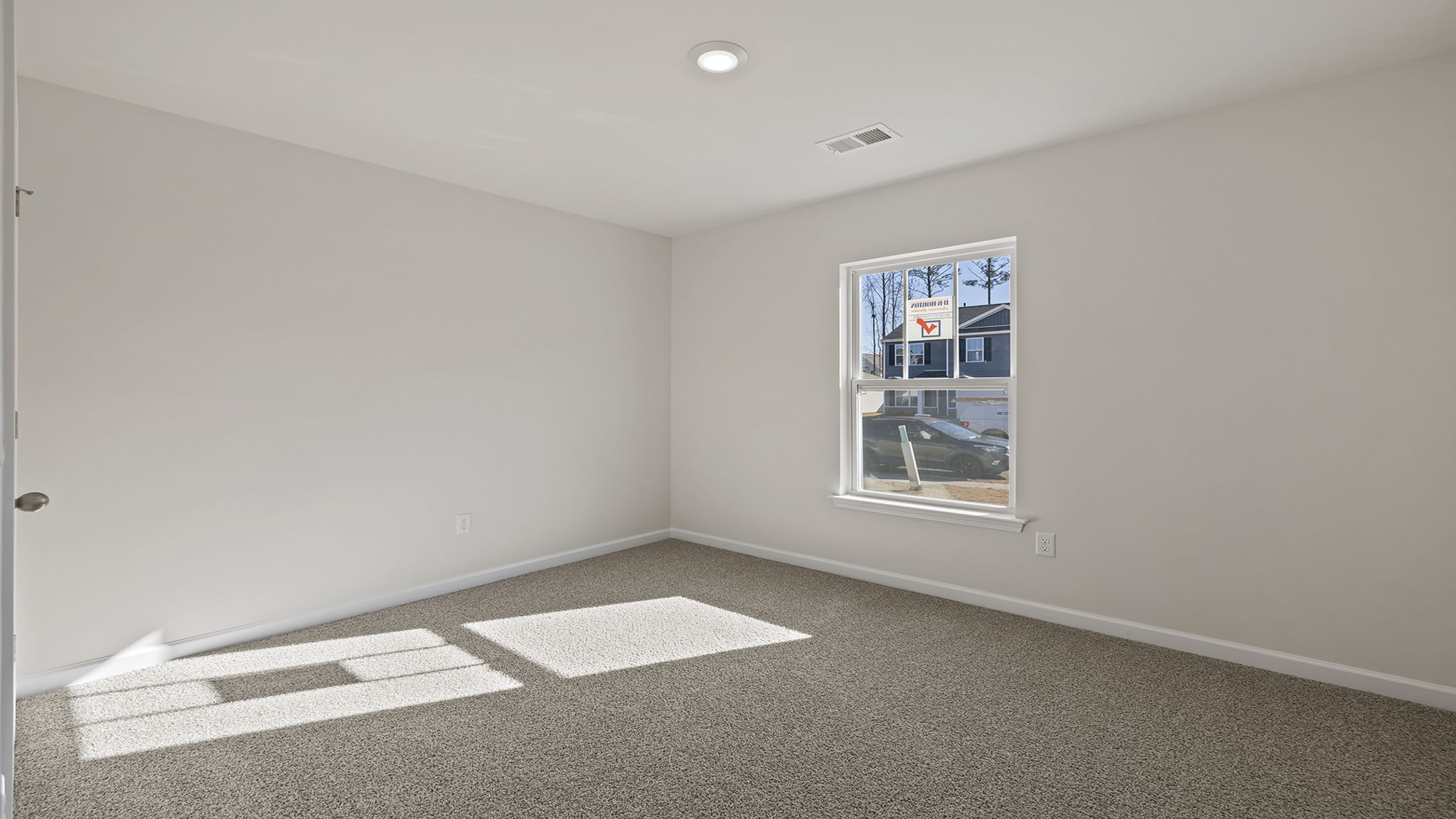 Front bedroom with window and carpet.