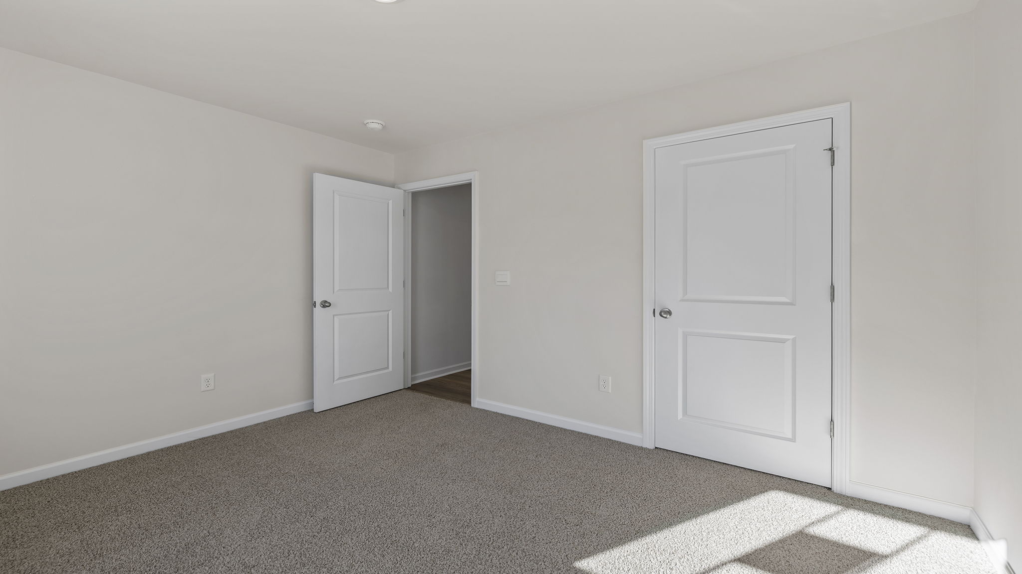 Front bedroom with window and carpet.