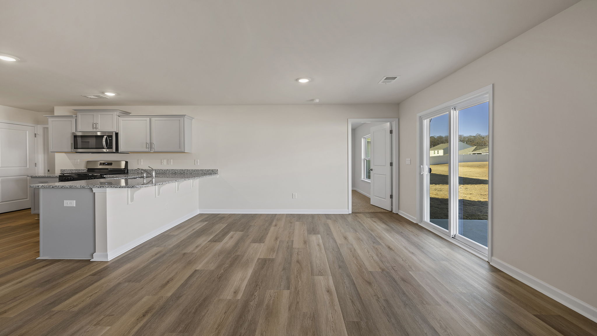 View of kitchen, dining area and entrance to primary bedroom.