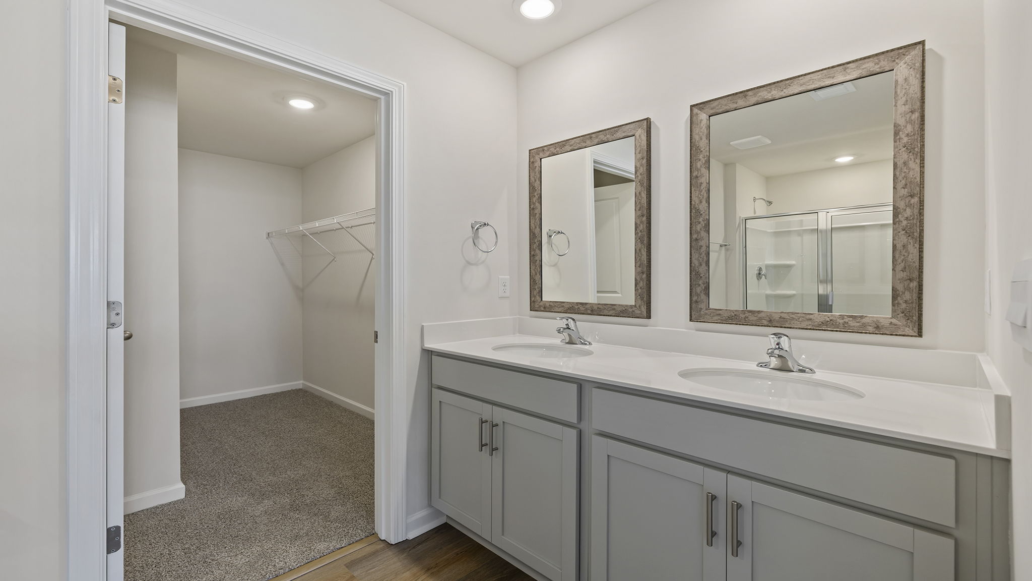 Primary bathroom with dual sink vanity and mirrors.