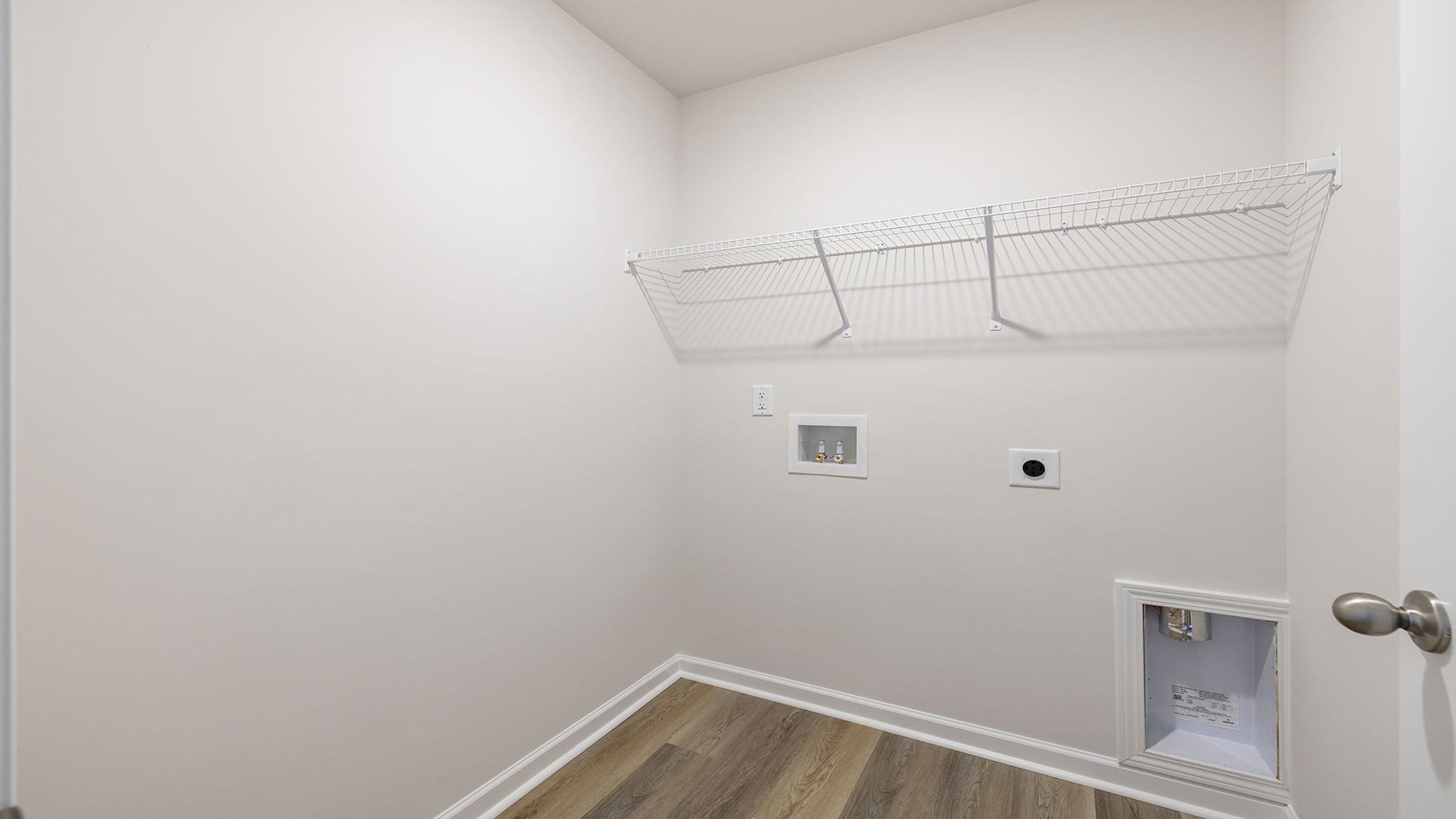 Walk-in laundry room with shelving.