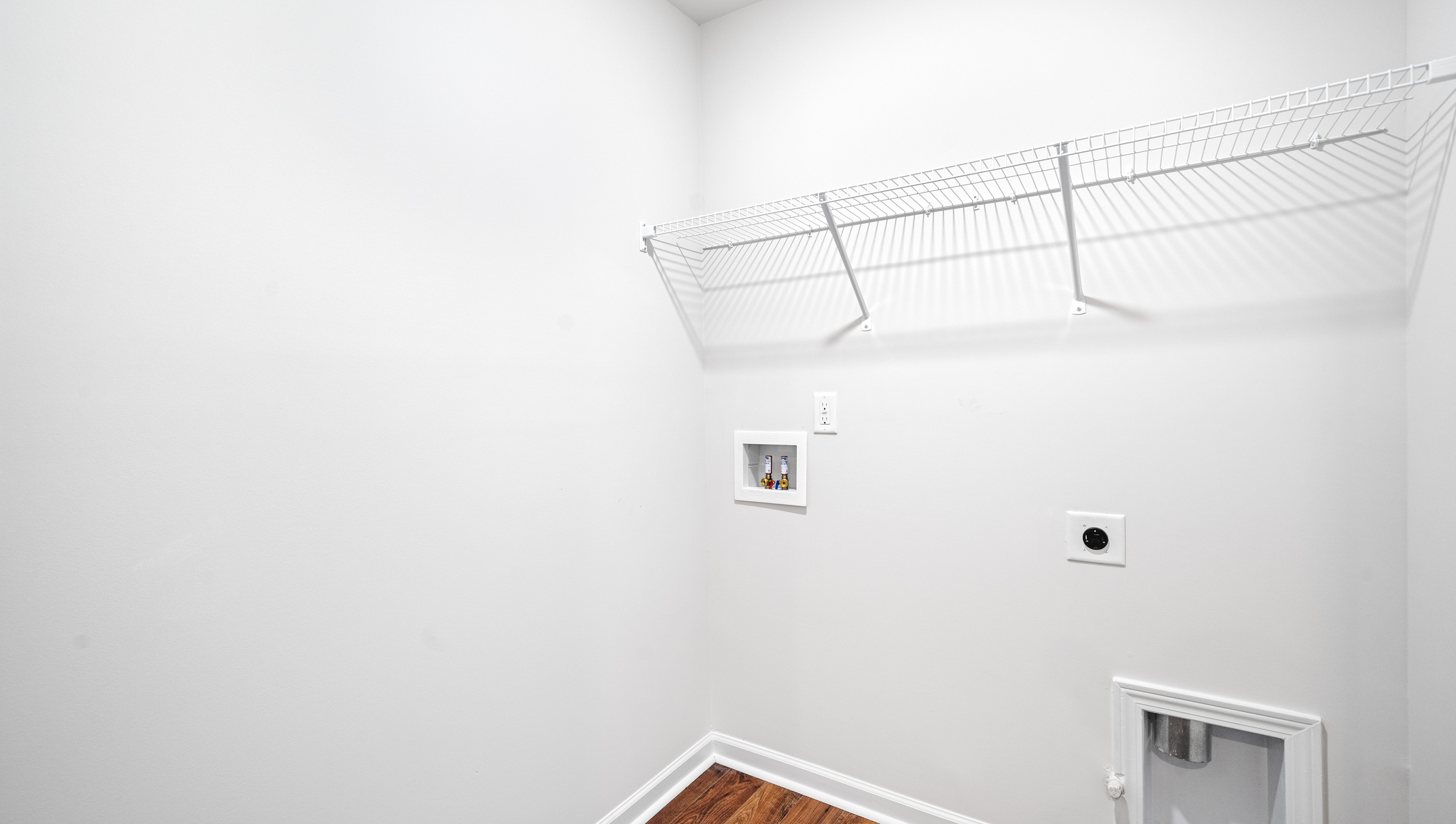 Laundry room with hanging storage racks.