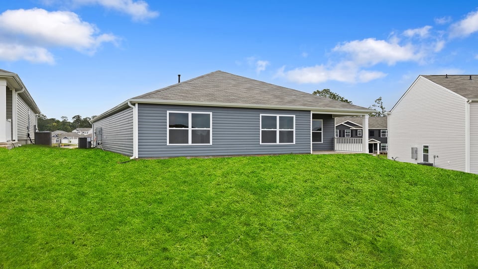 Back exterior of home with large backyard.