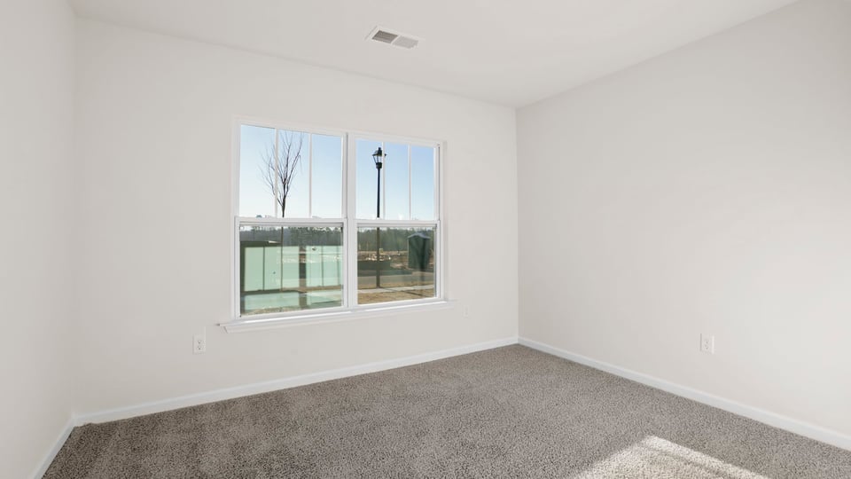 Bedroom with carpet and windows.