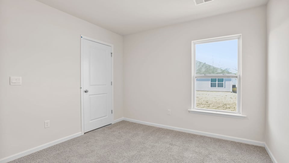 Bedroom with carpet and windows.