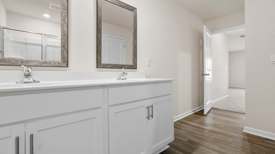 Primary bathroom with dual sink vanity and mirrors.