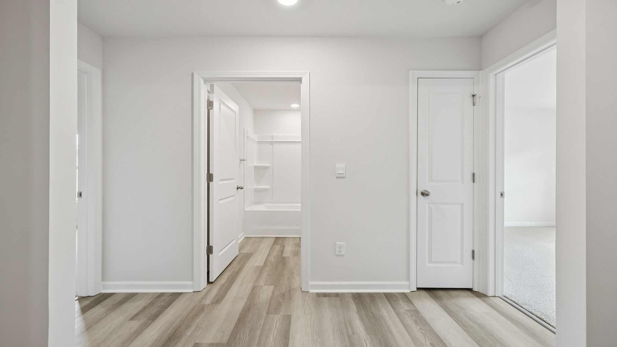 View of hallway noting hall bathroom and entrance to the bedroom.