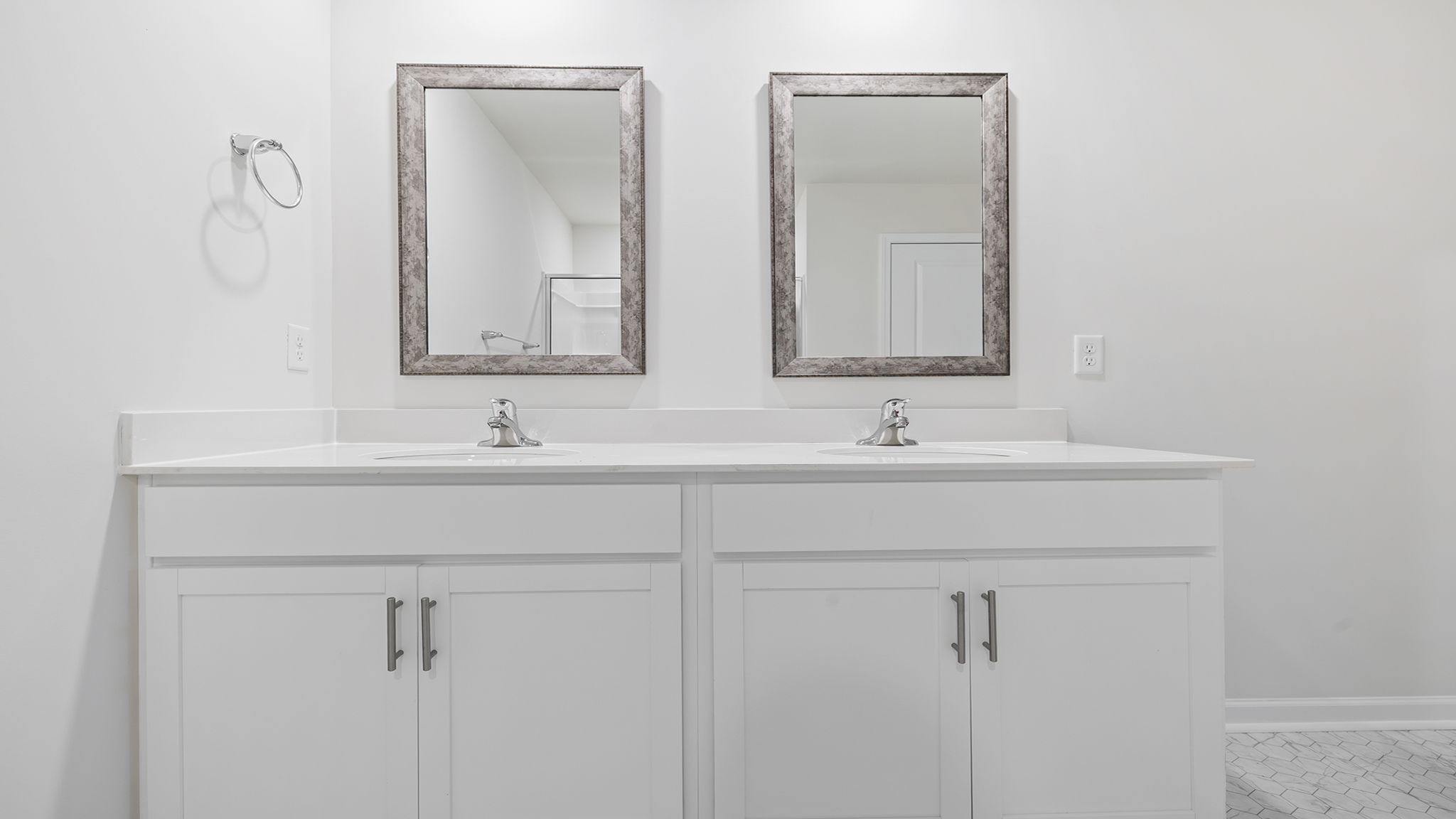 Primary bathroom with dual sink vanity and mirrors.