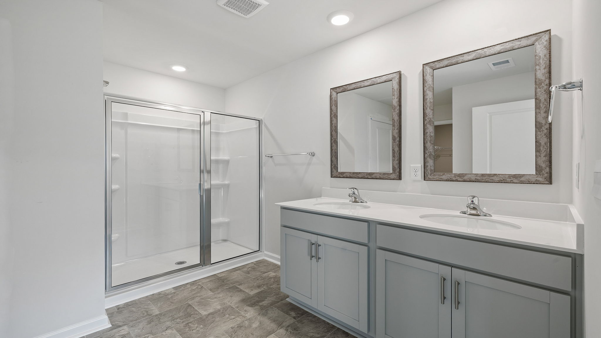 Primary bathroom with dual sink vanity and walk-in shower.