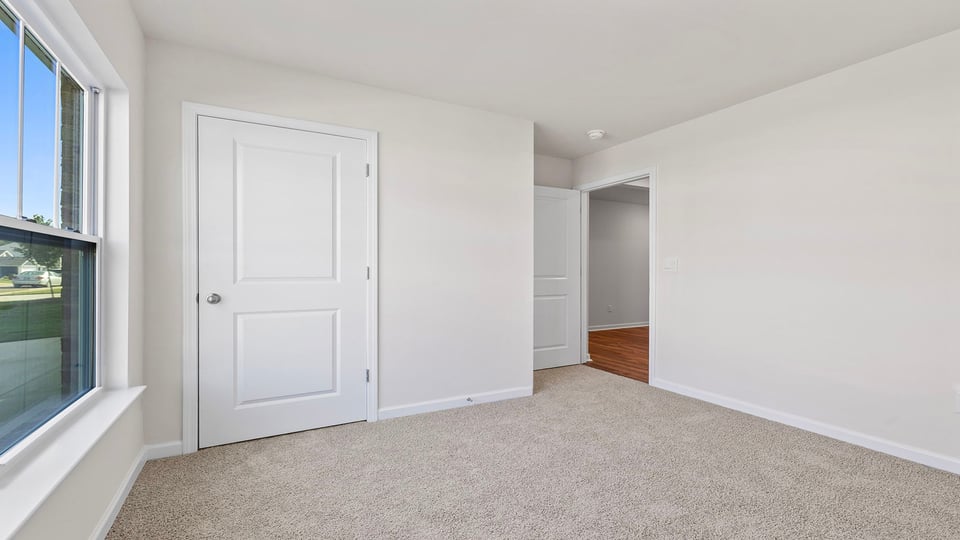 Bedroom with window and carpet.