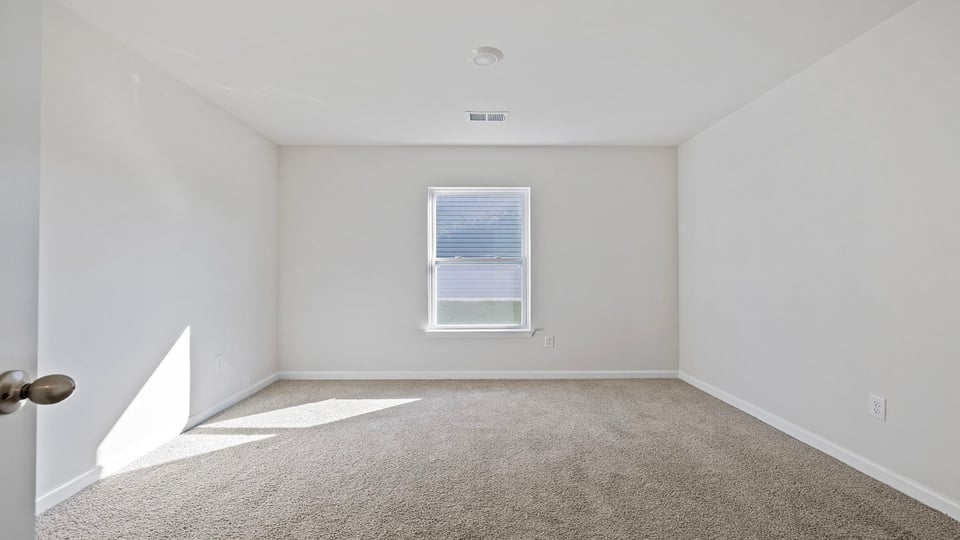 Bedroom with window and carpet.