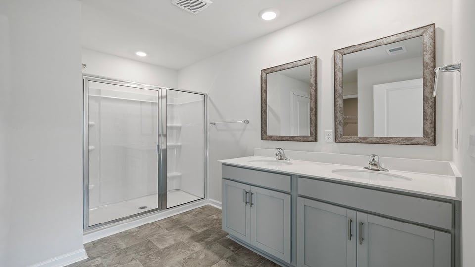 Primary bathroom with dual sink vanity and walk-in shower.