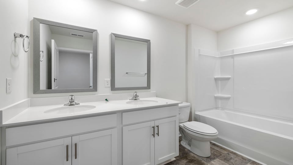 Bathroom with double vanity sink and tub.