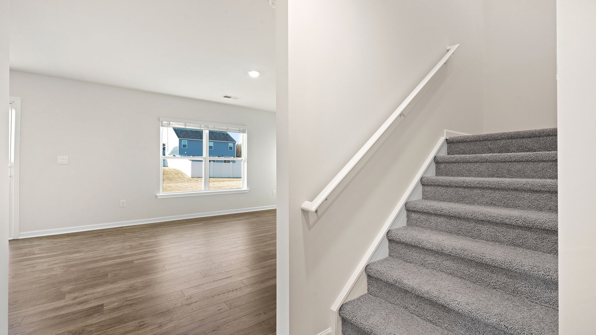 View of stairwell and family room large windows.