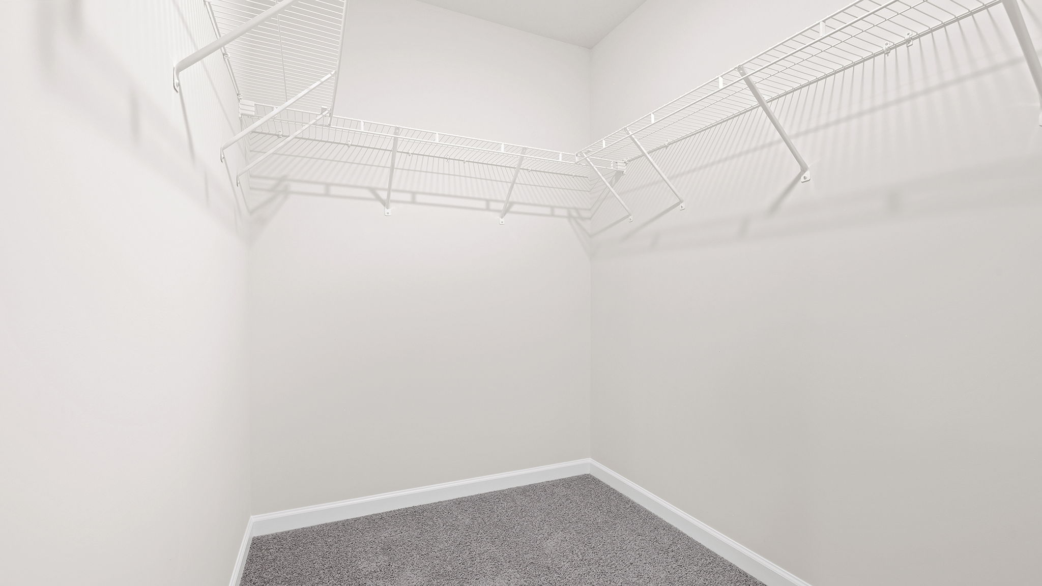 Primary bedroom walk-in laundry room with shelving.