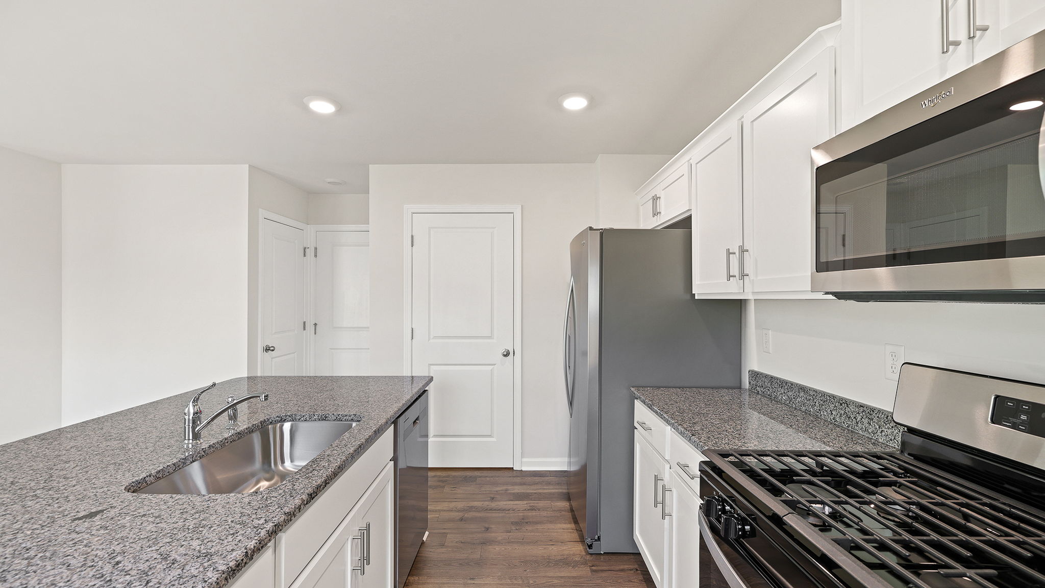 White cabinetry and quartz countertops.