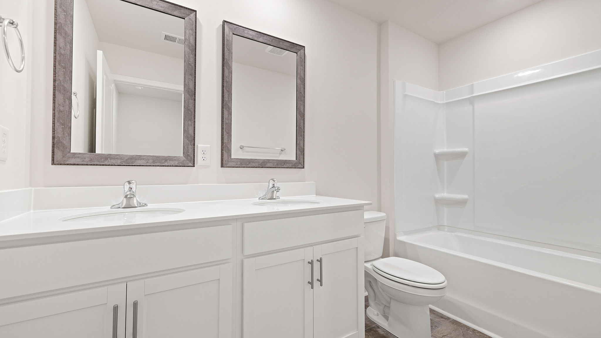 Hall bathroom with dual sink vanity and combination shower / tub.