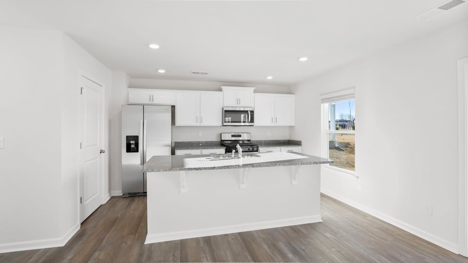 Kitchen with island and quartz countertops.
