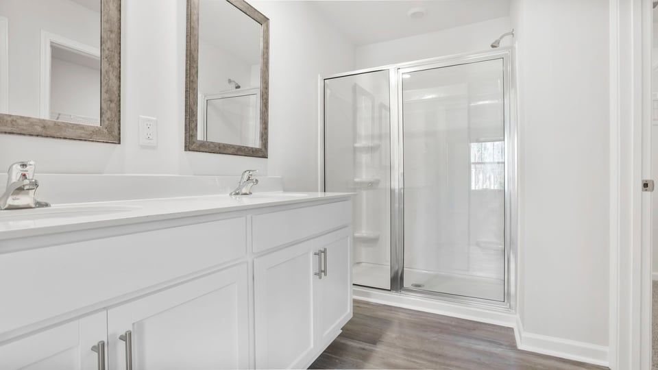 Primary bathroom with dual sink vanity and walk-in shower.