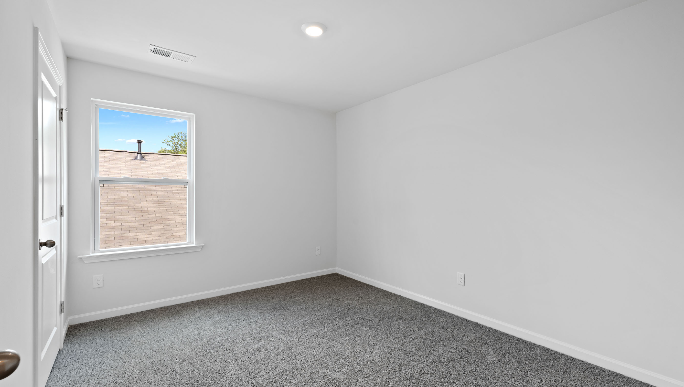 Bedroom with carpet and window.