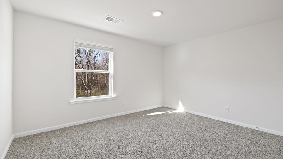 Bedroom with carpet and window.