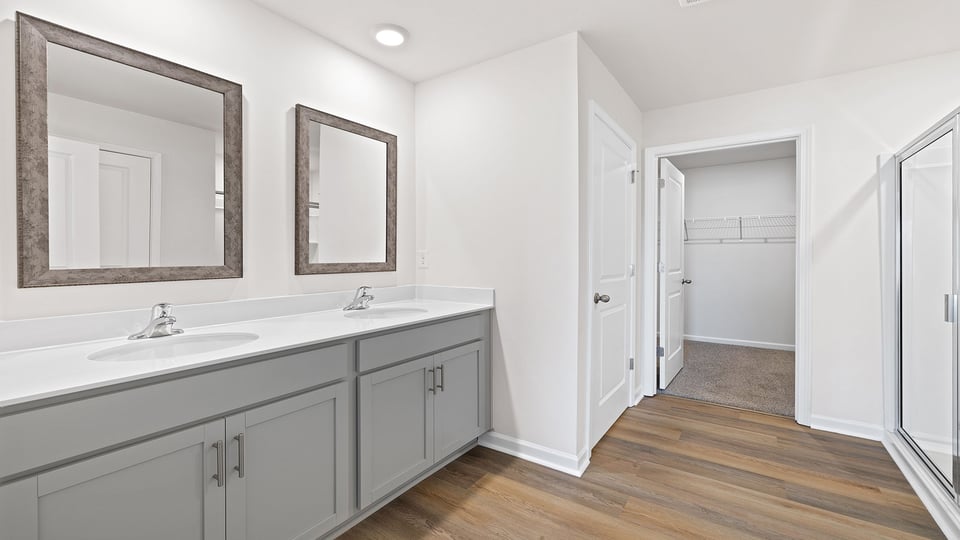 Primary bathroom with dual sink vanity and mirrors.