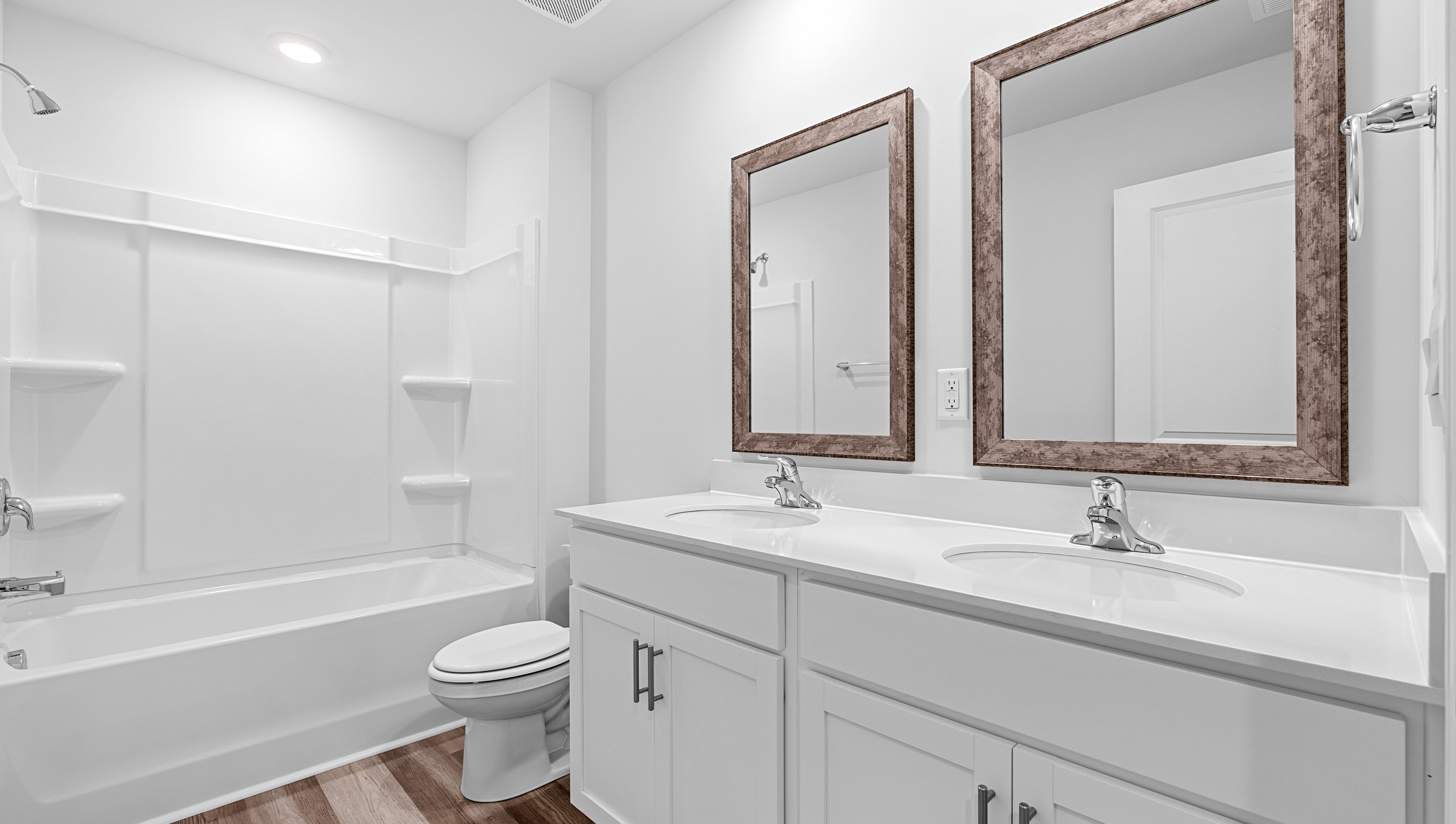 Hall bathroom with dual sink vanity and combination shower / tub.